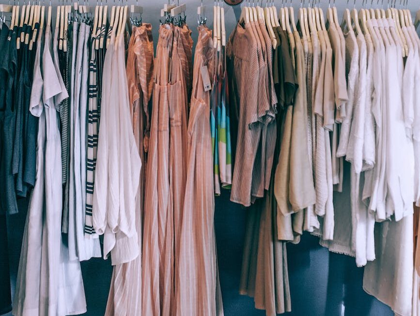 collection of female clothes on rack in boutique