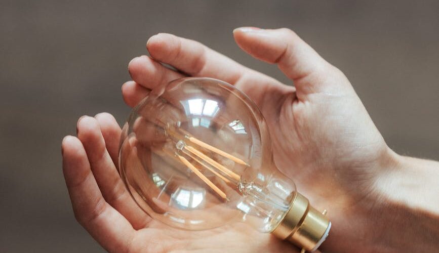 unrecognizable woman demonstrating light bulb in hands