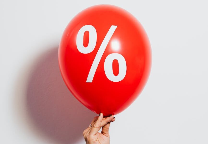 person holding a red balloon with percentage symbol