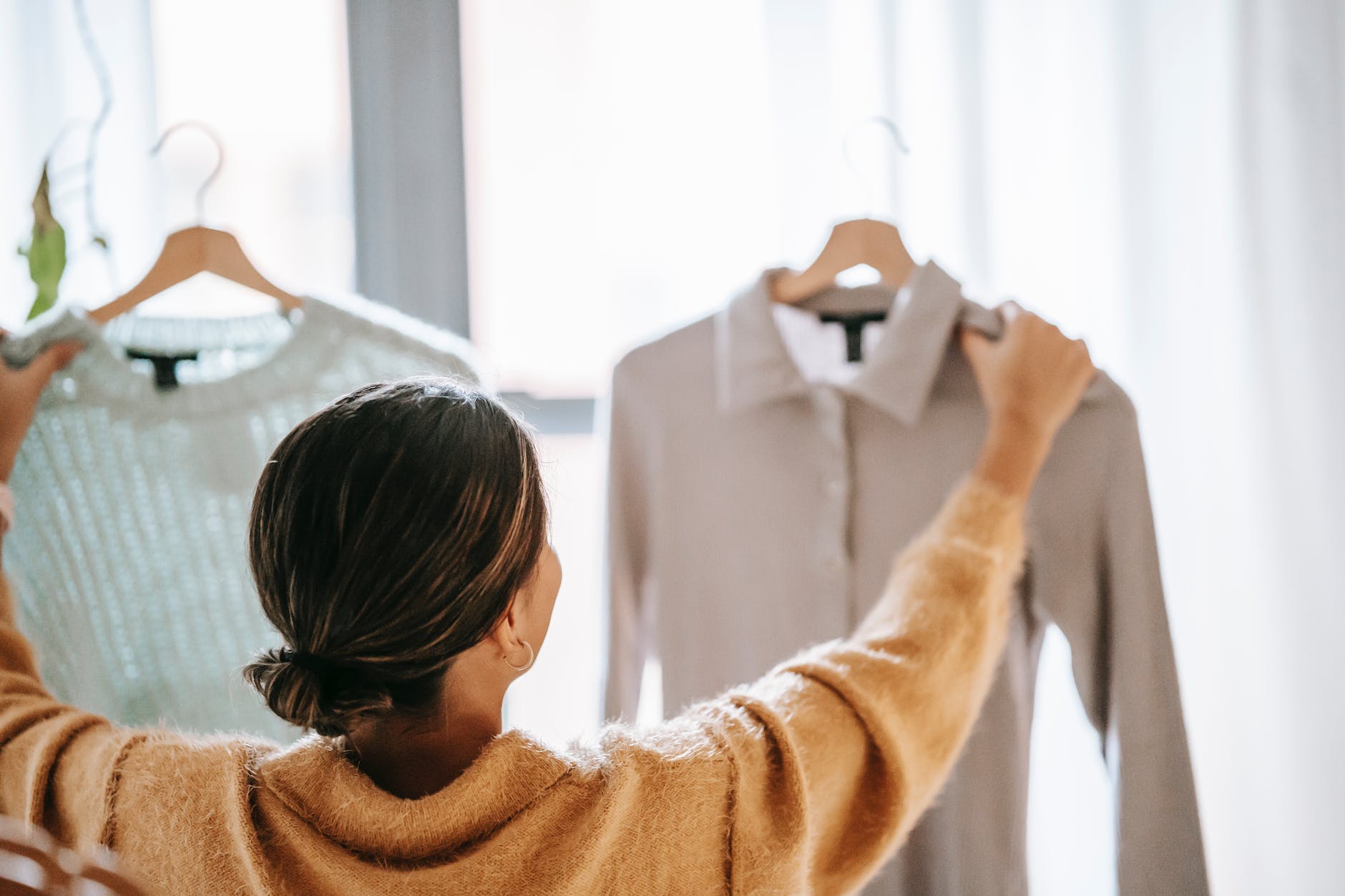 anonymous woman choosing clothes in store