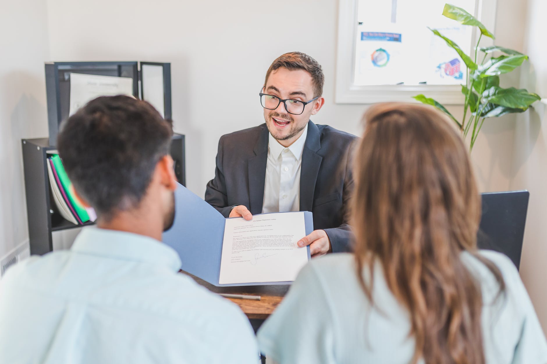 a broker showing a couple the mortgage contract